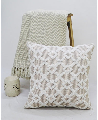 Beige and off-white geometric throw pillow with a knit throw and ceramic vase