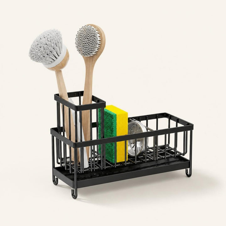 Black metal sink caddy holding two dish brushes, a sponge and a scrubber