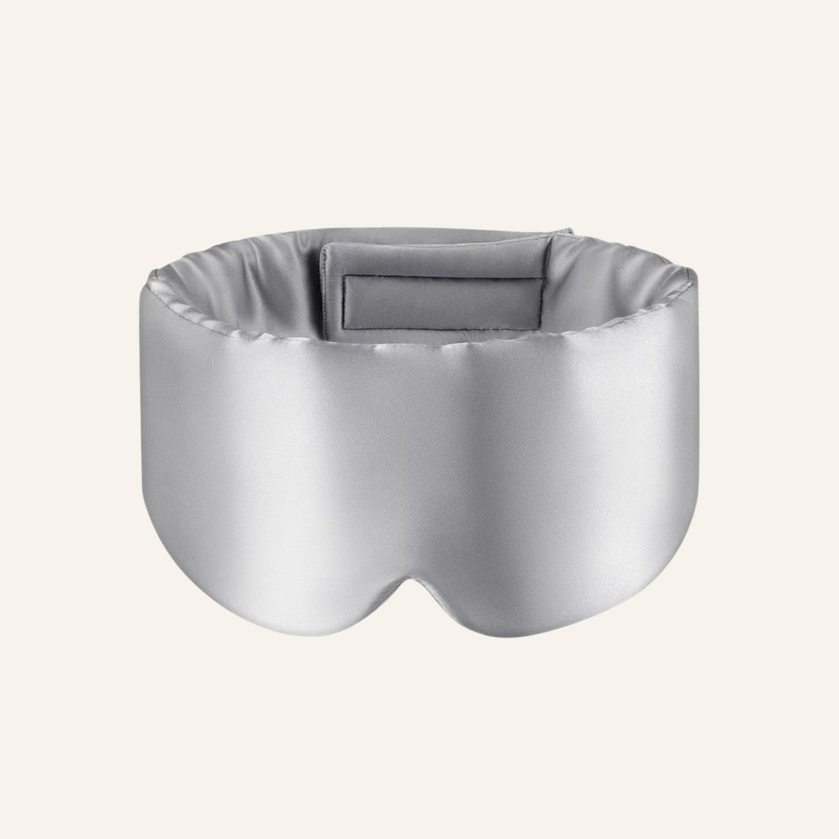 Light gray mulberry silk sleep mask on a warm ivory background