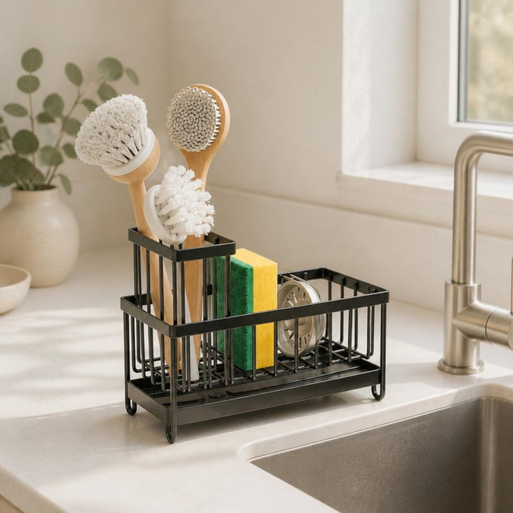 Sink caddy with brushes and sponge on a white kitchen counter beside the sink