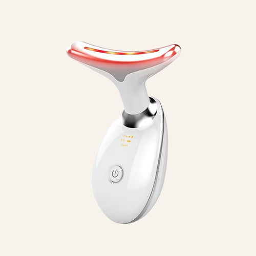White 7-color LED neck and face device on a warm ivory background