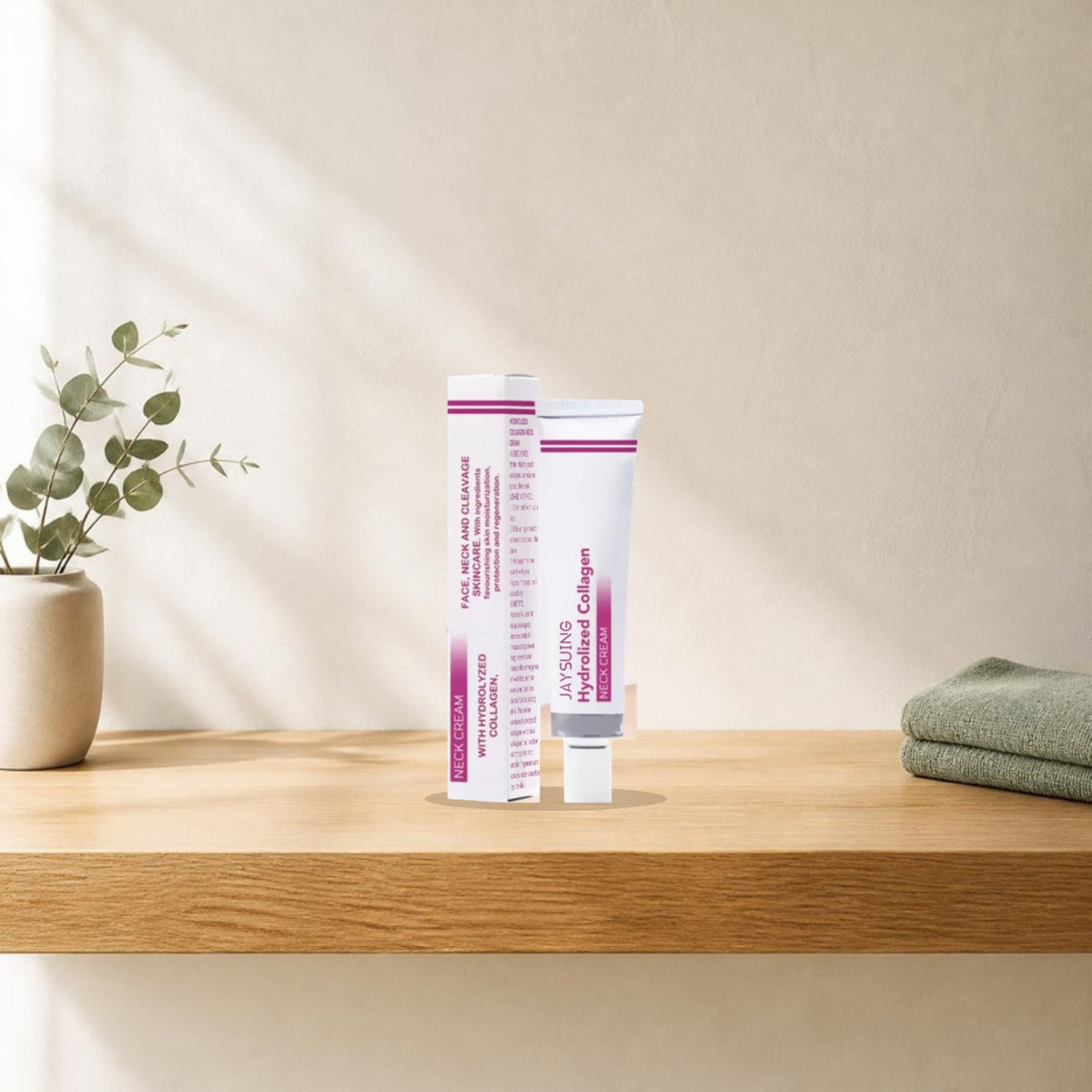 Collagen neck cream tube and box on a light oak bathroom shelf with eucalyptus and a sage towel