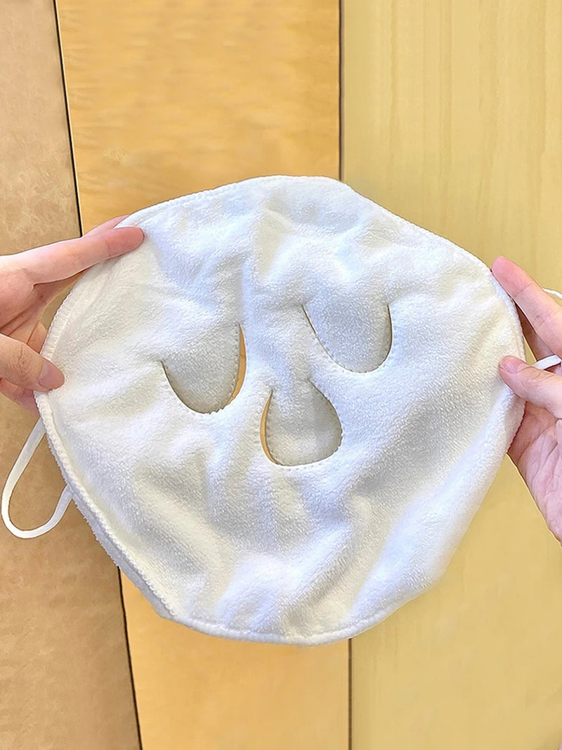 Three-hole compress face towel held flat, showing eye and mouth openings