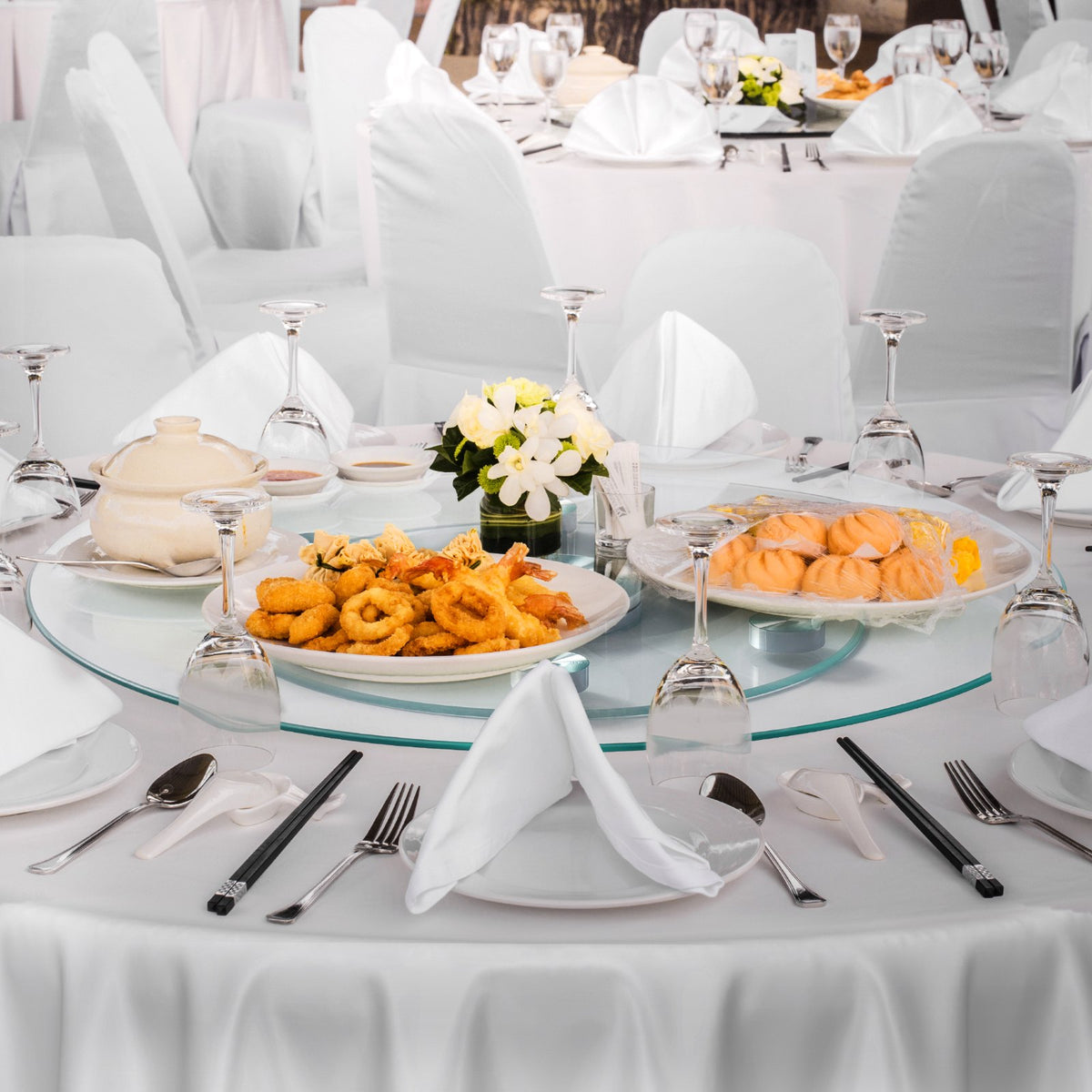 Glass lazy susan with dishes on a round banquet table