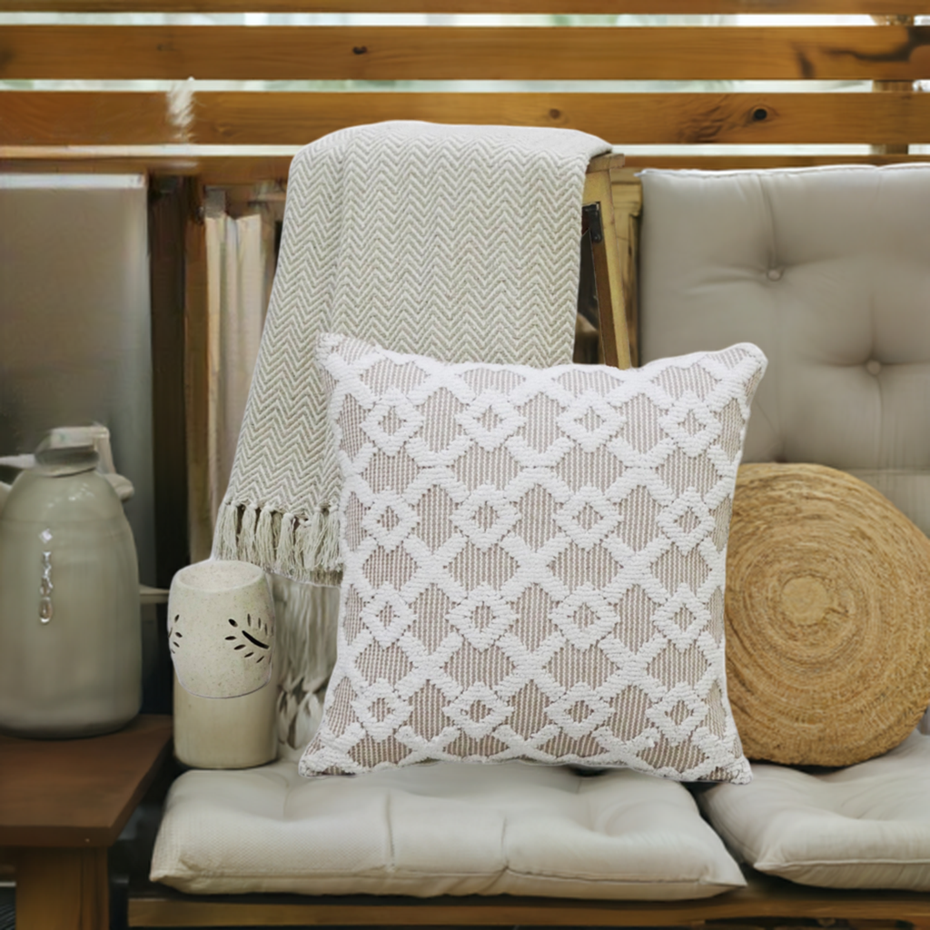 Beige geometric textured throw pillow on a cushioned bench with a knit throw