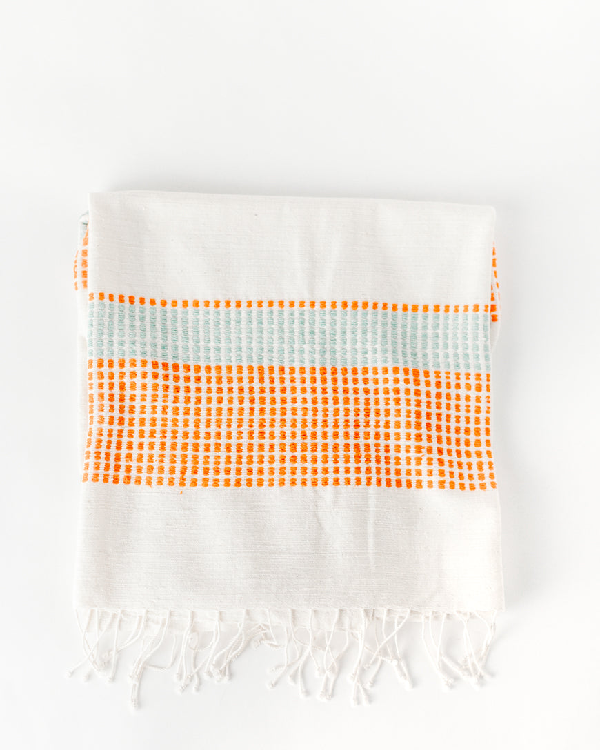 Folded Camden handwoven cotton throw in Azure and Tangerine with knotted fringe