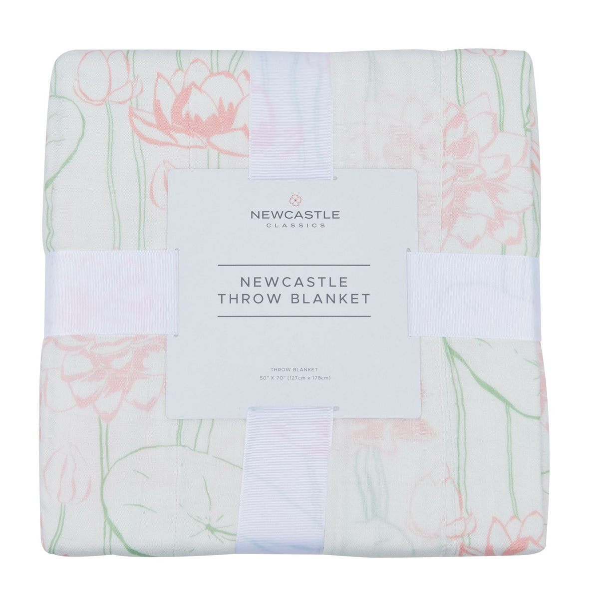 A folded throw blanket with a pink and green floral pattern on a white background, wrapped in a white ribbon with a white paper label that reads 'NEWCASTLE CLASSICS NEWCASTLE THROW BLANKET'.